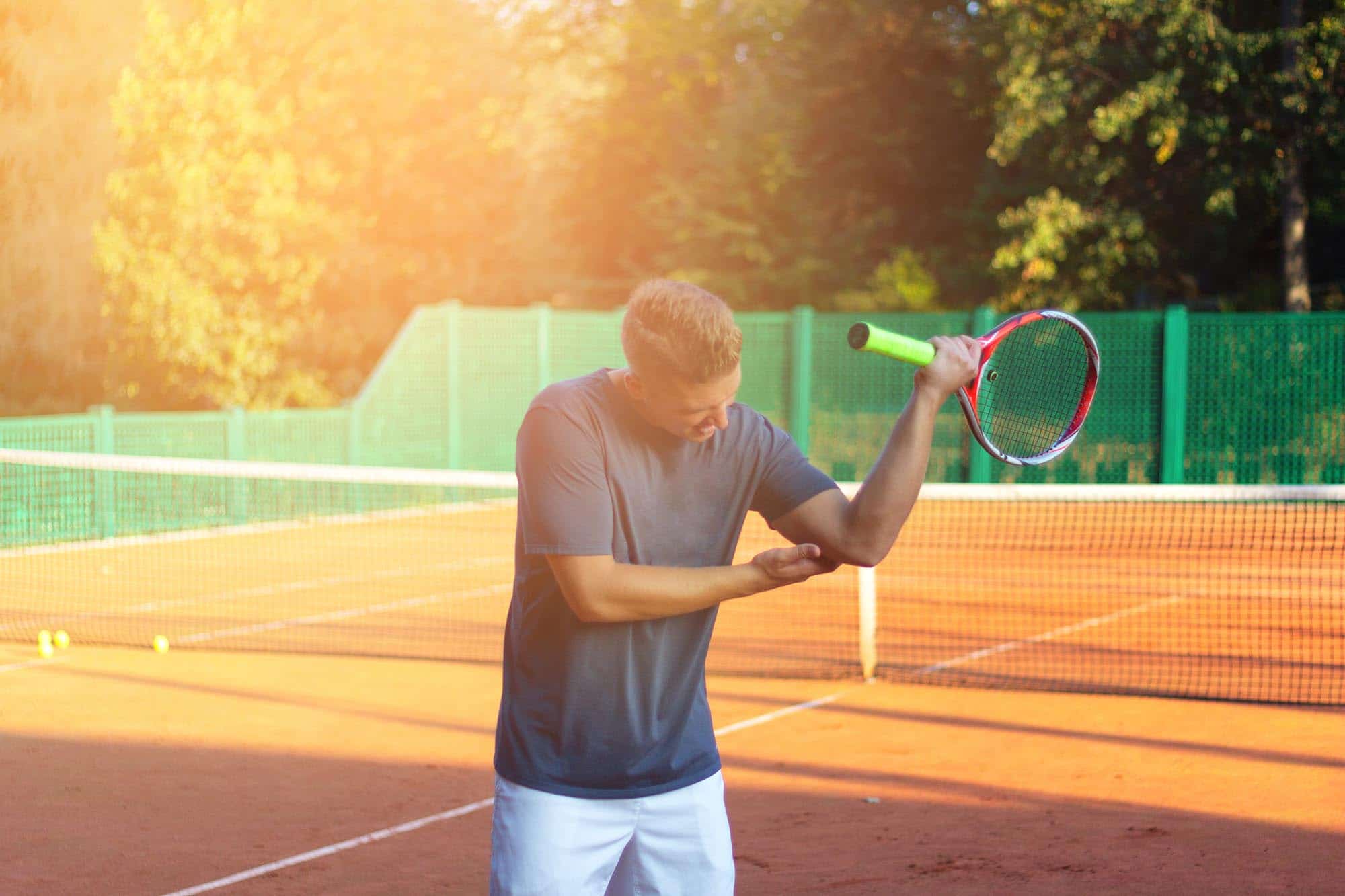 Man playing tennis with discomfort in his elbow