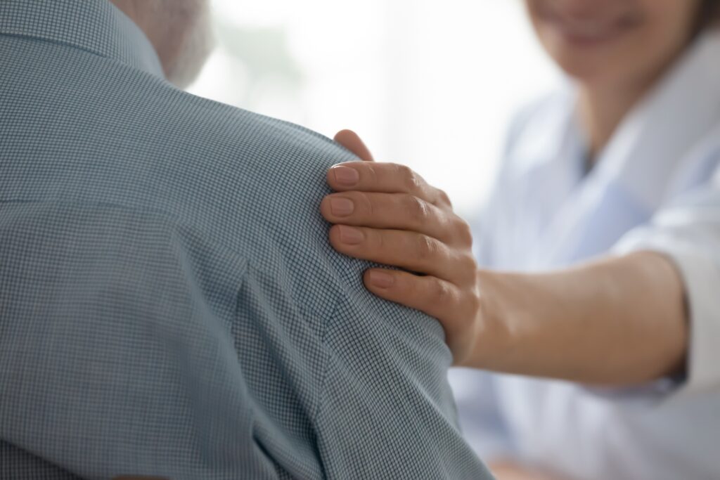 Understanding Your Reverse Shoulder Replacement Scar: Healing and Care Tips. Dr. McClintock and his team comforts his male patient on their journey to recovery.